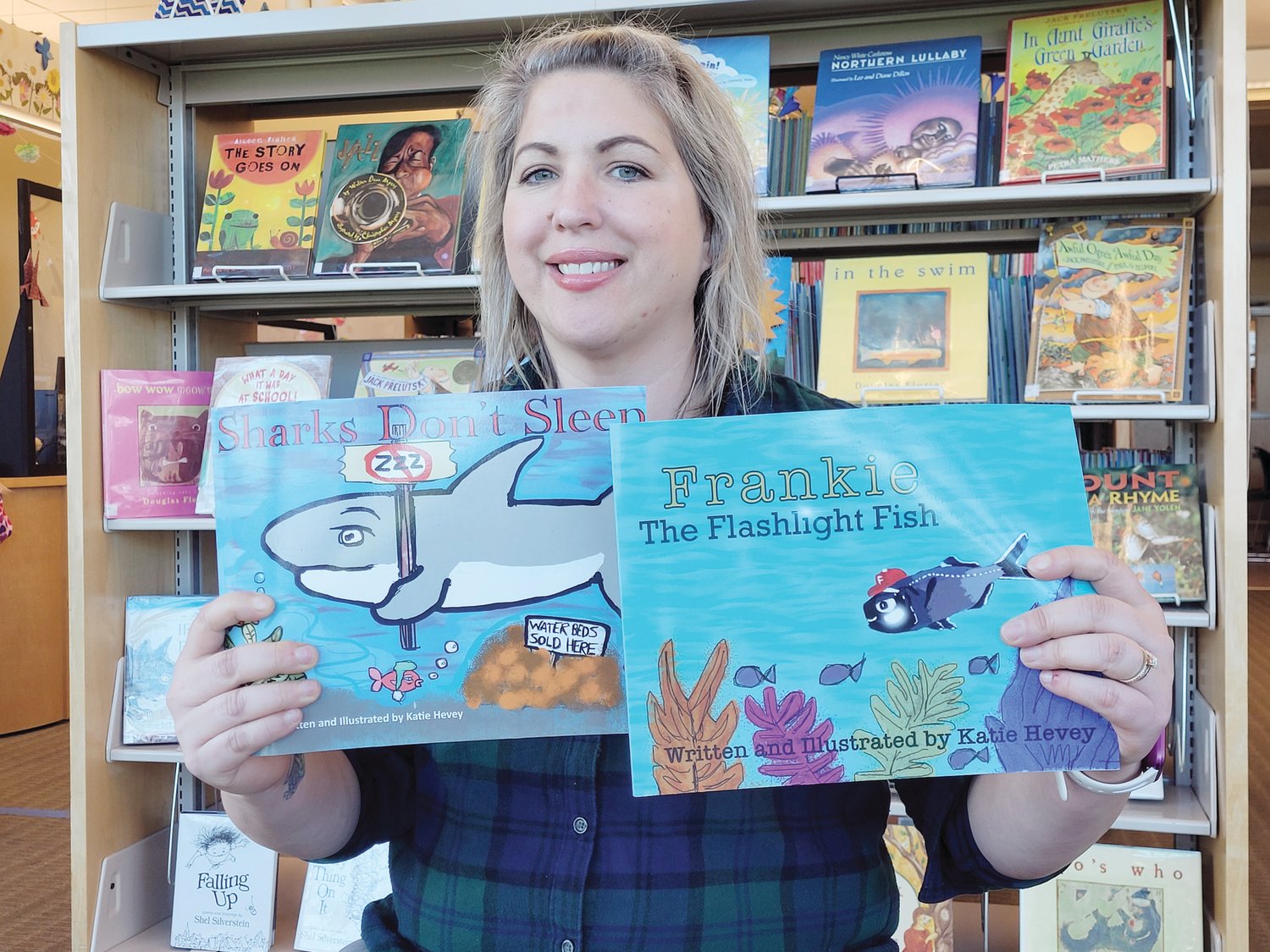 OCEAN STATE AUTHOR: Katie Hevey sat for an interview among the stacks of children’s books downstairs at the Marion J. Mohr Memorial Library in Johnston. She brought copies of her two books, “Frankie The Flashlight Fish” and “Sharks Don’t Sleep.”